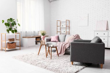 Oturma odasının içinde kanepe, masa ve küp takvimi var.