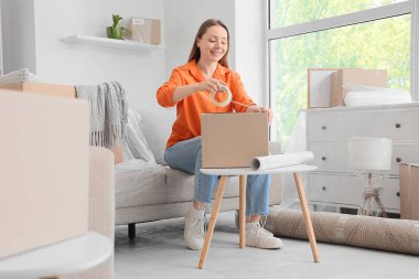 Taşındığı gün odada kaset çeken genç bir kadın.