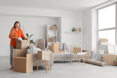 Taşınırken odadaki eşyaları boşaltan genç bir kadın.