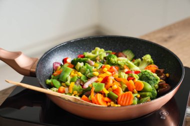 Kızartma tavası ve lezzetli sebzeler mutfakta, yakın plan.