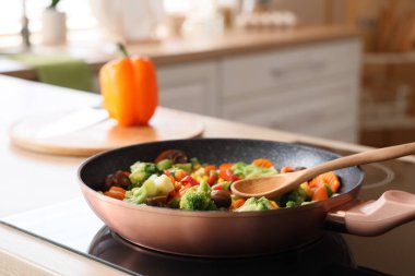 Mutfakta lezzetli sebzeli tava ve kaşık, yakın plan.