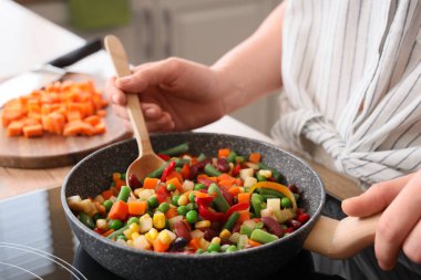 Mutfakta lezzetli sebzeler kızartan kadın, yakın plan.