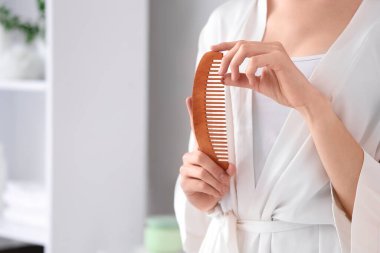 Saçları banyoda taranmış güzel genç bir kadın, yakın plan.