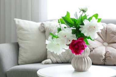 Oturma odasındaki sehpanın üzerinde güzel şakayıklar olan vazo, yakın plan.