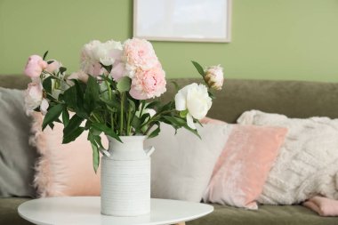 Sehpanın üzerinde bir buket güzel şakayık olan bir vazo şık bir oturma odasında, yakın plan.