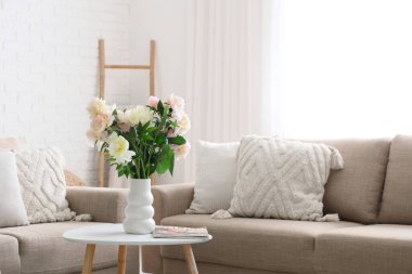 Gri koltukları, kahve masası ve güzel şakayıkları olan şık bir oturma odası.