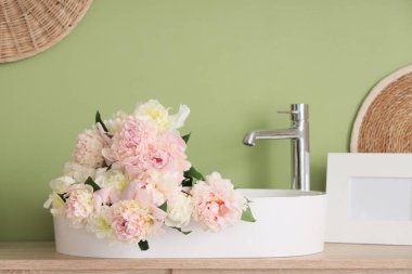 Güzel şakayık demetleriyle dolu lavabo şık bir banyoda, yakın plan.