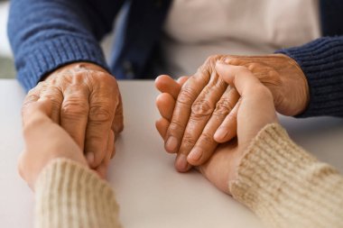 Büyükannesi ile el ele tutuşan bir kadın, yakın plan. Bakım kavramı