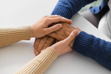 Büyükannesi ile el ele tutuşan bir kadın, yakın plan. Bakım kavramı