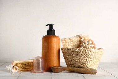 Beyaz fayansların üzerine anti-selülit masajı için kozmetik ürünler.