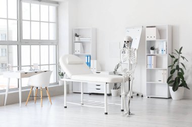 Tıp bürosunun içinde insan iskeleti modeli