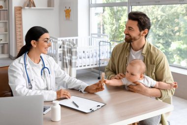 Babası ve bebeği klinikteki çocuk doktorunu ziyaret ediyor.