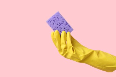 Pembe arka planı temizlemek için kauçuk eldiven tutuyordu.