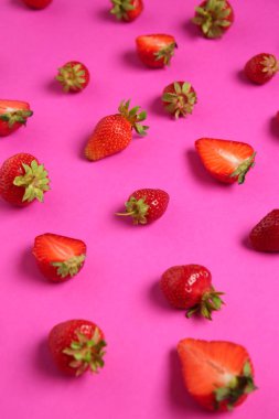 Pembe arka planda taze olgun çilekler, yakın plan.