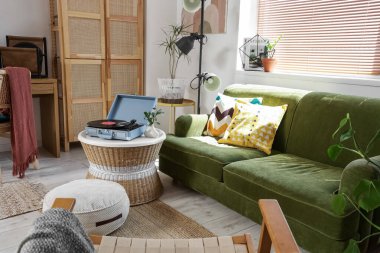 Oturma odasının içinde, masada ve koltukta pikap var.