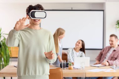 Ofiste VR gözlüğü kullanan genç adam.