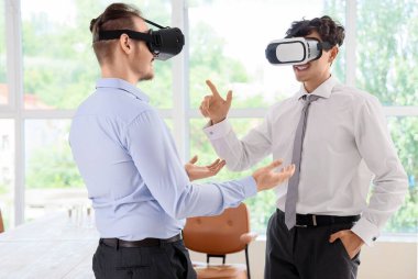 Erkek iş arkadaşları ofiste VR gözlüğü kullanıyorlar.