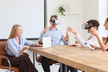Genç iş arkadaşları ofiste VR gözlüklerini kullanıyorlar.