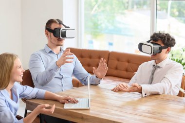 Genç iş arkadaşları ofiste VR gözlüklerini kullanıyorlar.