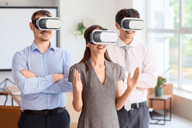 Genç iş adamları ofiste VR gözlüğü kullanıyorlar.