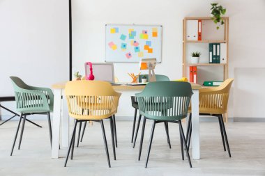 Masa, tahta ve raf ünitesi olan konferans salonunun içi.