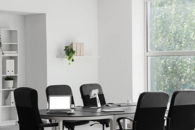 Laptop, tablet bilgisayar ve kahve fincanları konferans salonundaki iş toplantısı için hazırlandı.