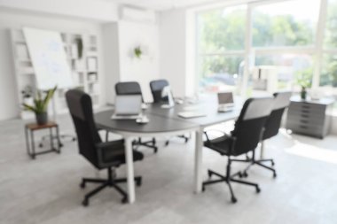 Masası, tablosu ve bitkileriyle konferans salonunun bulanık görüntüsü