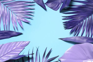 Mavi arkaplanda farklı neon yapraklardan yapılmış çerçeve