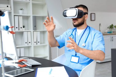 Hastanede VR gözlüğü kullanan bir erkek doktor.