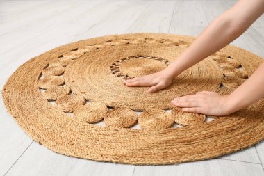 Kadın elleri ve yerde hasır halı.