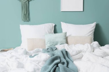 Yatak odasındaki nane duvarının yanında büyük, rahat bir yatak.