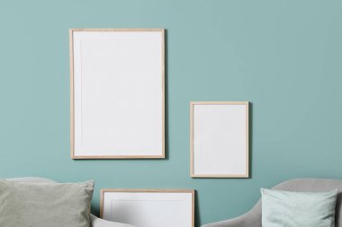 Oturma odasındaki naneli duvarda boş fotoğraf çerçeveleri, yakın plan.