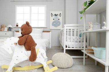 Yatak, bebek beşiği ve oyuncakları olan ışık odasının içinde.