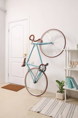 Koridorun içinde bisiklet, raf ve kapı var.