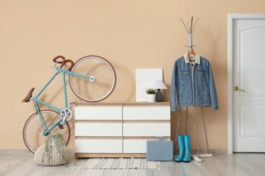 Koridorun içinde bisiklet, tuvalet ve elbise askısı var.