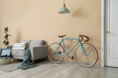 Oturma odasının içinde bisiklet, kanepe ve lamba var.