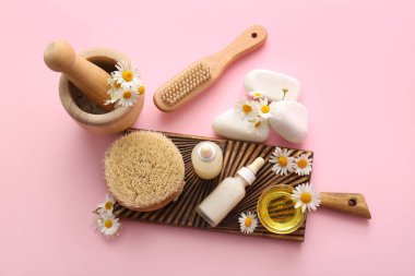 Pano, papatya çiçeği ve pembe arka planda kozmetik ürünleri içeren spa kompozisyonu