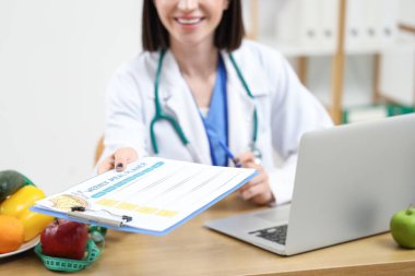 Ofiste yemek planlayıcısı olan kadın beslenme uzmanı, yakın plan.