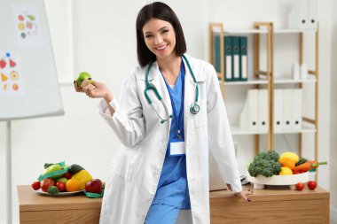 Ofisinde elma olan kadın beslenme uzmanı.