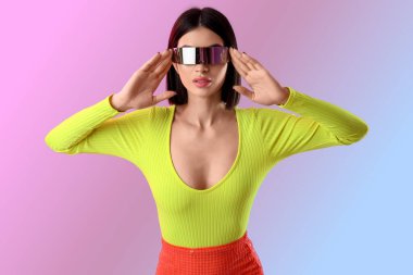 Işık arka planda VR gözlüklü genç kadın