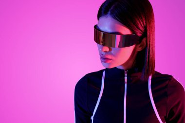 Pembe arka planda VR gözlüklü genç kadın, yakın plan.