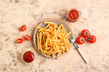 Lezzetli patates kızartması ve bej arka planda ketçap tabağı.