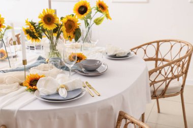 Tabaklarla servis edilen zarif masa, katlanmış peçete ve güzel ayçiçekleri, yakın plan.