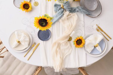 Tabaklarla servis edilen zarif masa, katlanmış peçeteler ve güzel ayçiçekleri, üst manzara.