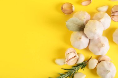 Sarı arka planda biberiyeli taze sarımsak ve defne yaprağı.