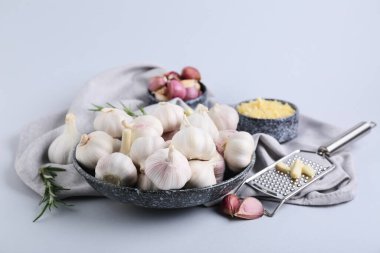 Taze sarımsaklı kase ve gri arka planda biberiye.