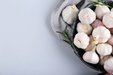 Taze sarımsaklı kase ve gri arka planda biberiye.