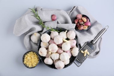 Taze sarımsaklı kaseler ve gri arka planda biberiye.