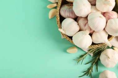 Taze sarımsaklı hasır kase ve turkuaz arka planda biberiye.