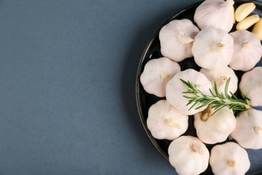 Taze sarımsaklı tabak ve gri arka planda biberiye.